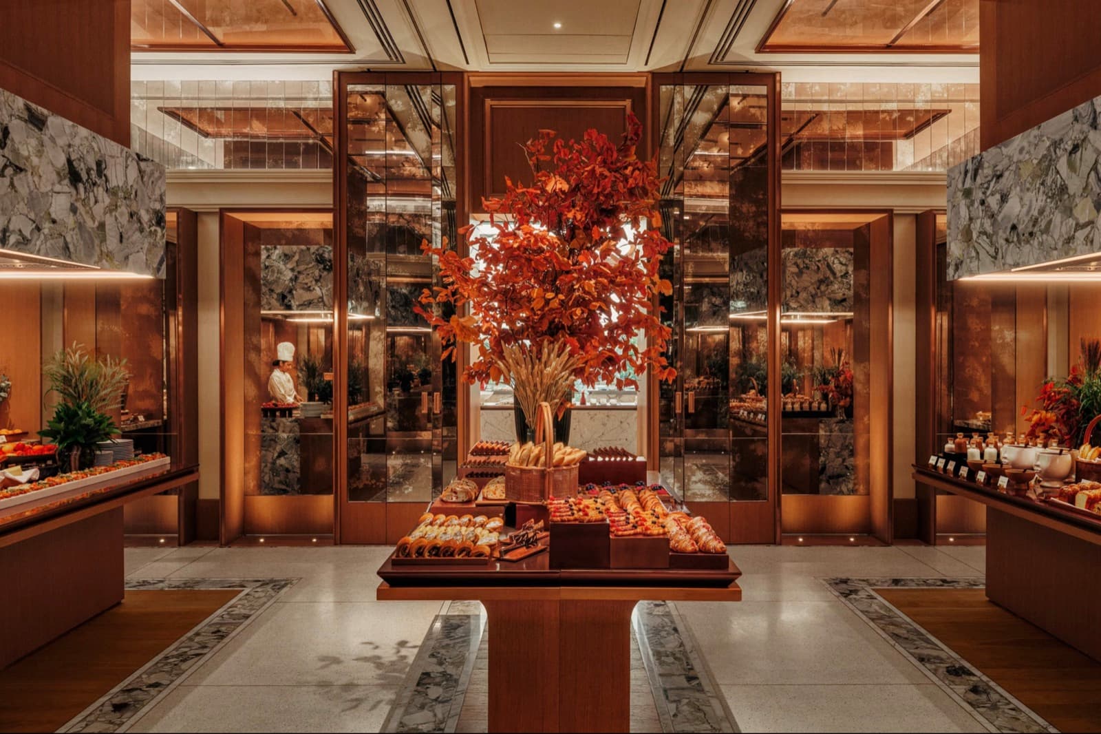 Buffet stations at The Fore, with pastries and breads on a central table beneath autumn foliage