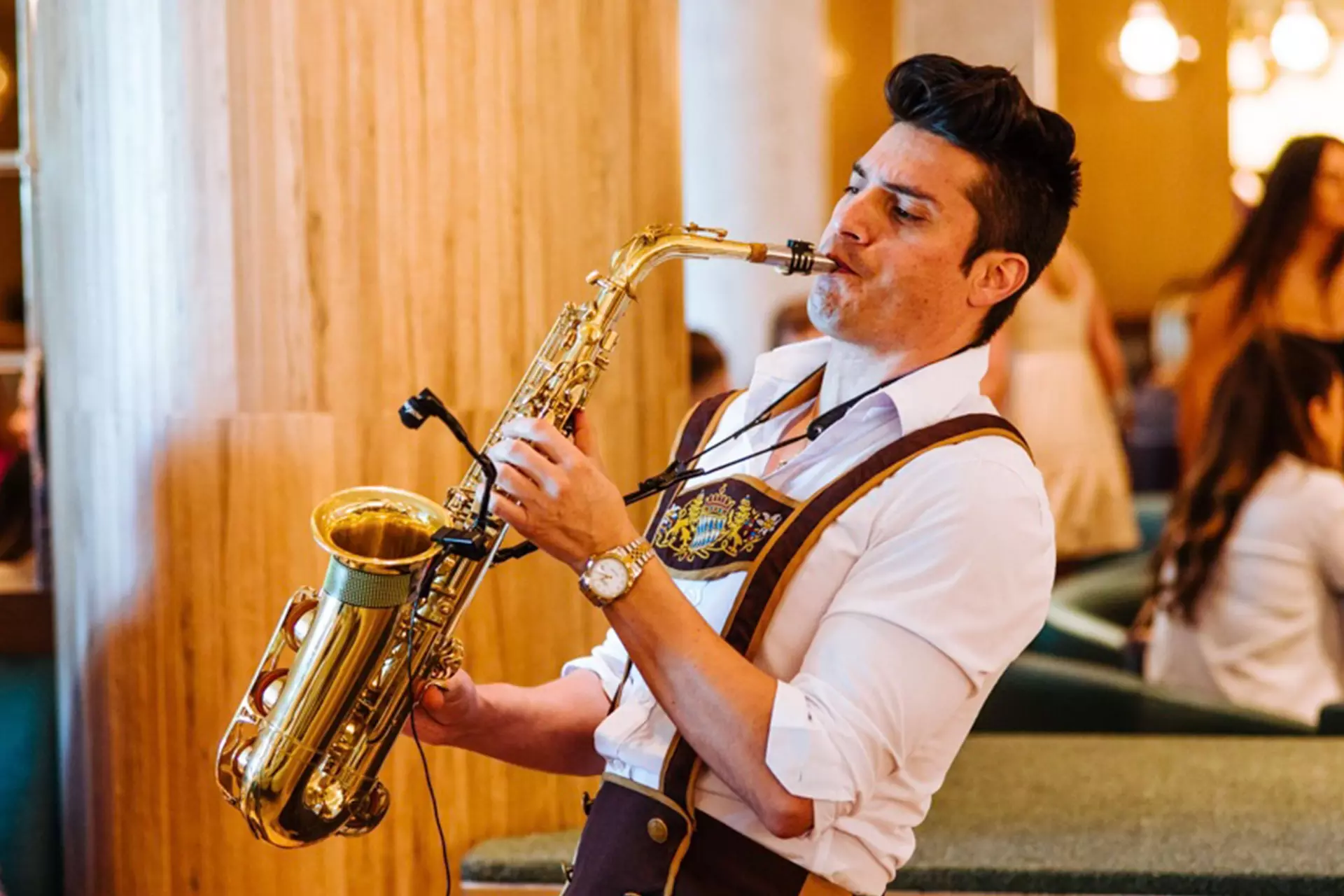 A saxophonist in Bavarian dress playing between the tables at Saffron